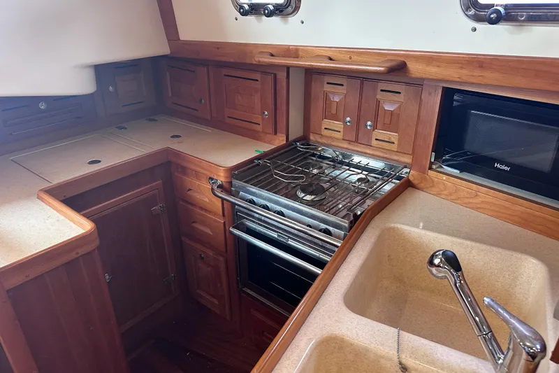 Slide: The Image of Wooden yacht kitchen with stove, sink, and microwave in a 2016 Tartan 4000 model. - 39