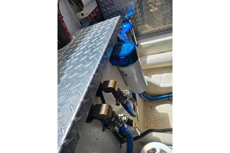 Slide: The Image of Engine compartment of 2004 Hustler 388 SLINGSHOT with blue hoses and metal components. - 11