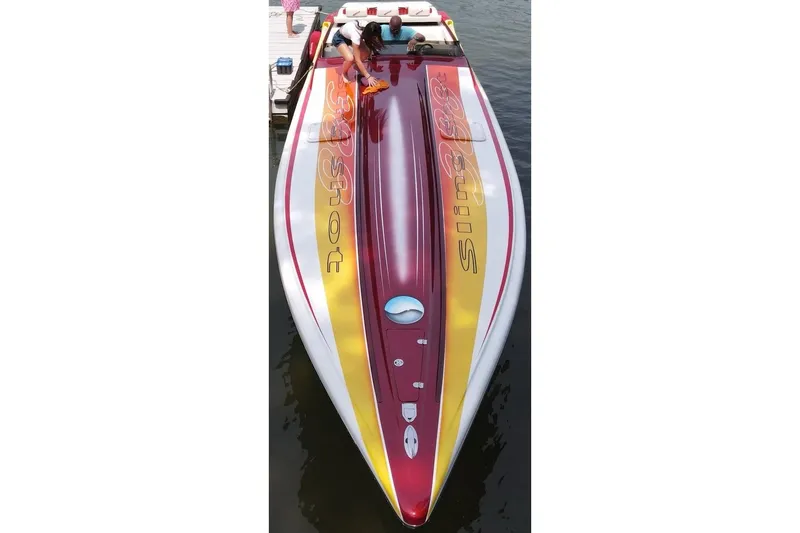 Slide: The Image of 2004 Hustler 388 SLINGSHOT speedboat with vibrant red and yellow design docked on water. - 3