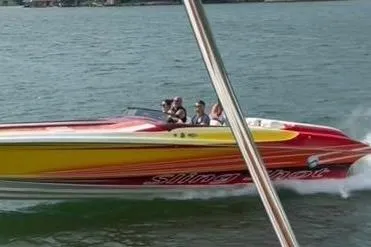 Slide: The Image of 2004 Hustler 388 SLINGSHOT speedboat cruising on a lake with passengers onboard. - 4