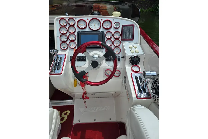 Slide: The Image of Dashboard of a 2004 Hustler 388 SLINGSHOT boat with red accents and multiple gauges. - 6