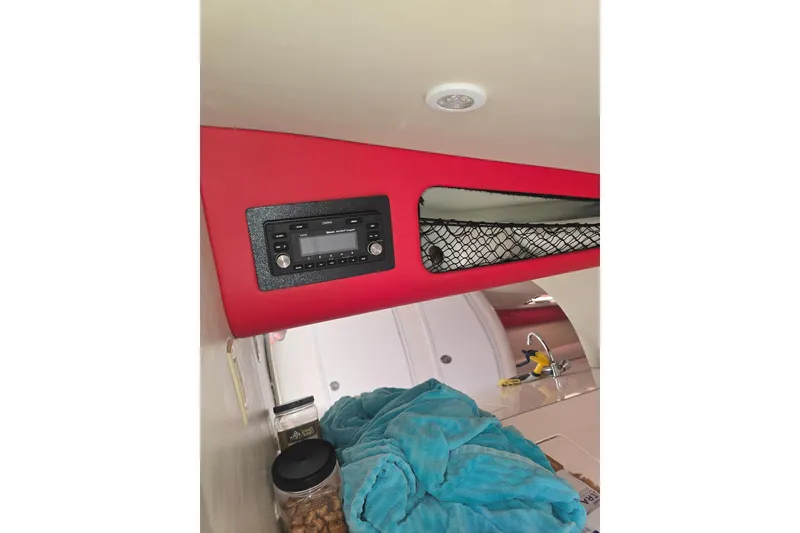 Slide: The Image of Interior of 2004 Hustler 388 SLINGSHOT with radio, storage net, and blue towel. - 9