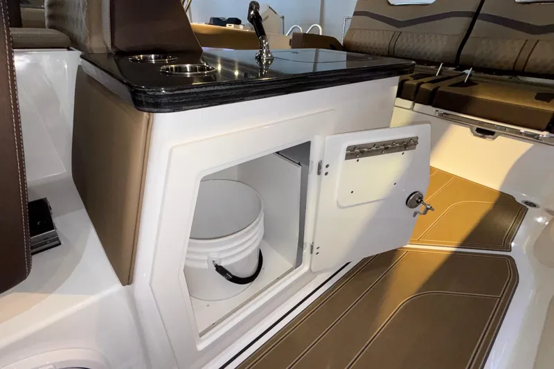 Slide: The Image of 2026 Monterey Elite 30 OB boat interior with open storage compartment and bucket. - 21
