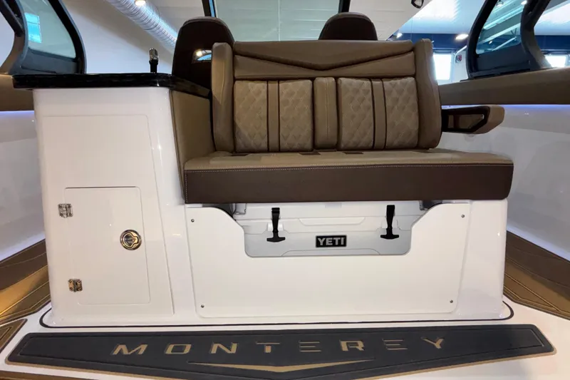 Slide: The Image of 2026 Monterey Elite 30 OB boat interior with cushioned seating and Yeti storage. - 24