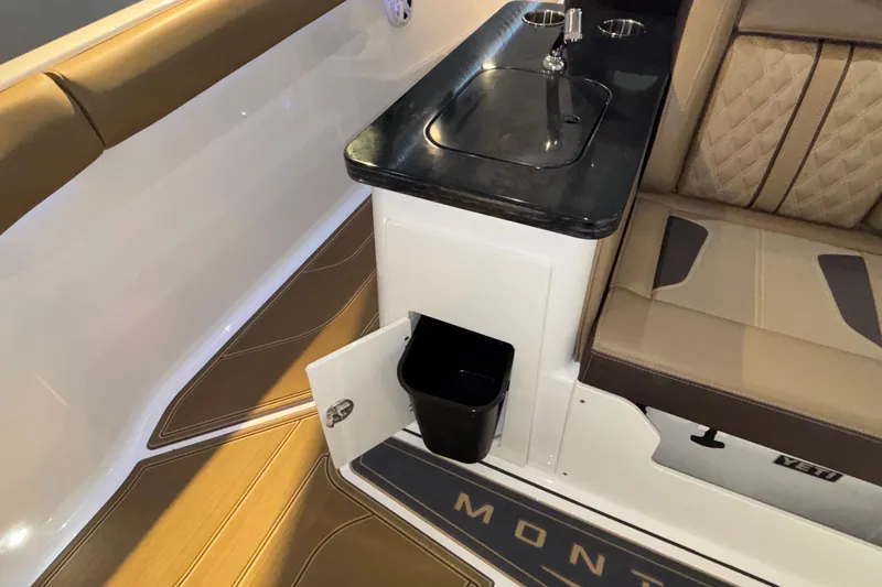 Slide: The Image of Interior of 2026 Monterey Elite 30 OB boat with sink, seating, and storage. - 25