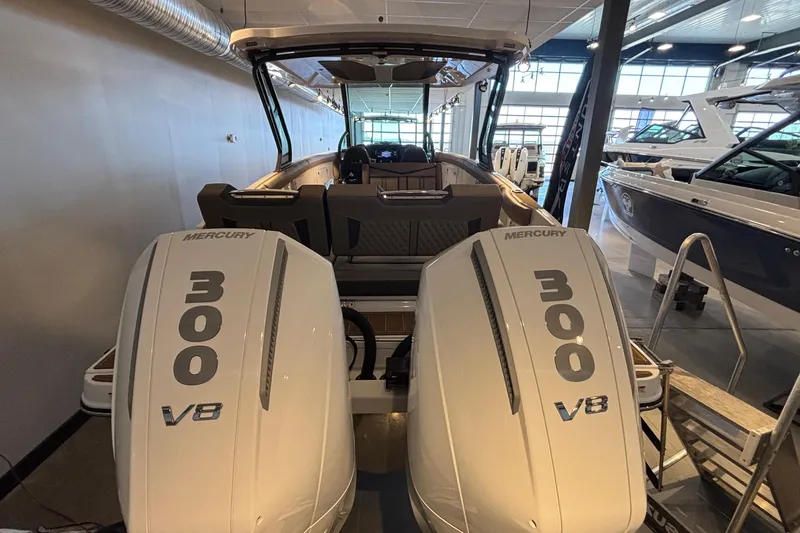 Slide: The Image of 2026 Monterey Elite 30 OB boat with twin Mercury 300 V8 engines in showroom. - 74