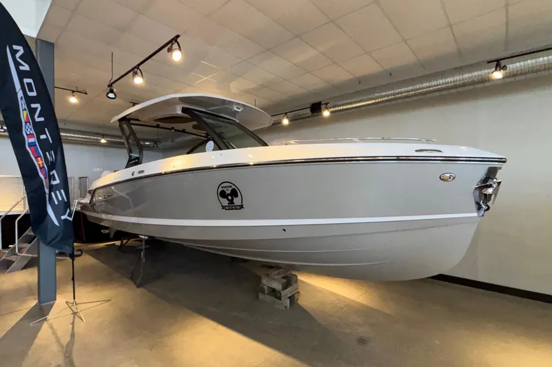 Slide: The Image of 2026 Monterey Elite 30 OB boat displayed indoors with sleek design and modern features. - 79