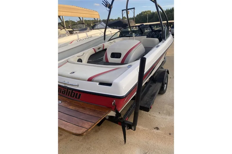 Slide: The Image of 2002 Malibu Response LX boat with red and white design on a trailer. - 6