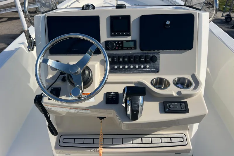Slide: The Image of 2021 Boston Whaler 250 Dauntless boat dashboard with steering wheel and controls. - 10