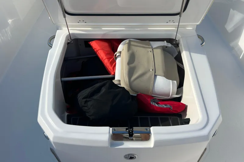 Slide: The Image of Open storage compartment on 2021 Boston Whaler 250 Dauntless boat with life jackets and gear. - 16