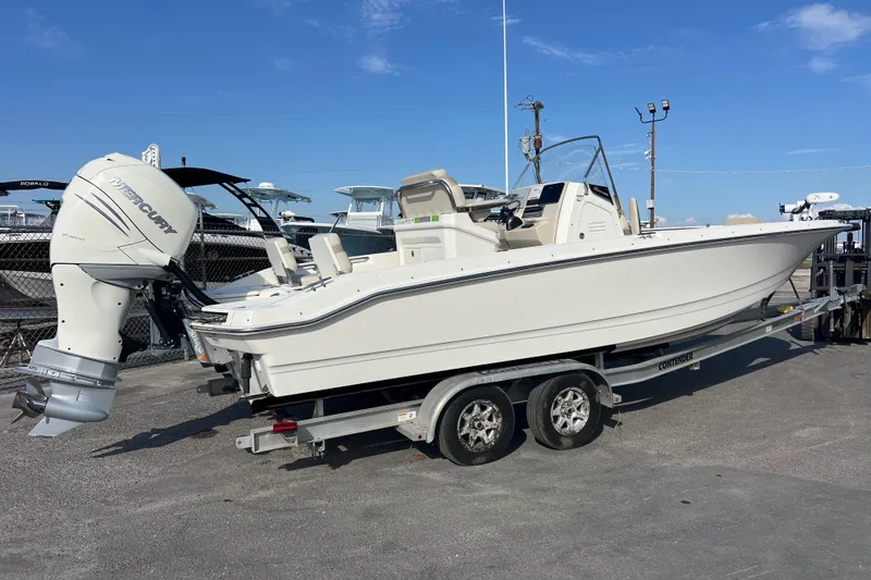 Slide: The Image of 2021 Boston Whaler 250 Dauntless boat on trailer with Mercury engine, parked outdoors. - 3