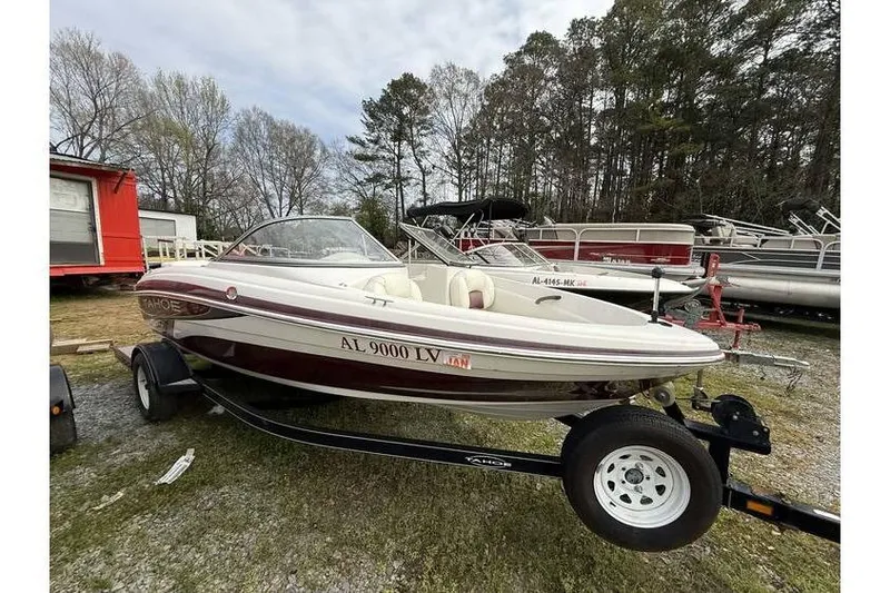 The Image of 2009 Tahoe Q4 SF boat on trailer, parked outdoors with trees in background. - 0