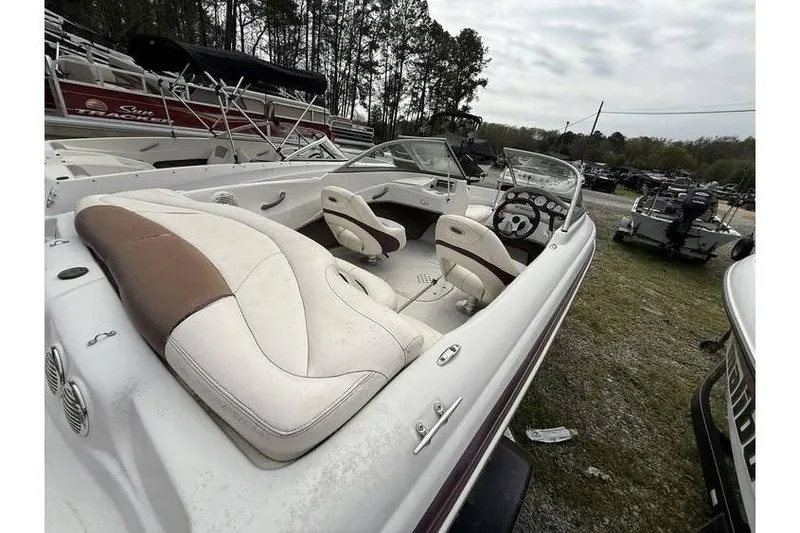 Slide: The Image of 2009 Tahoe Q4 SF boat interior with white and brown seating, parked outdoors. - 10