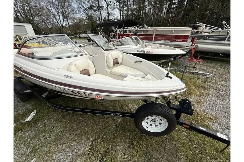 Slide: The Image of 2009 Tahoe Q4 SF boat on trailer, parked outdoors with other boats. - 3