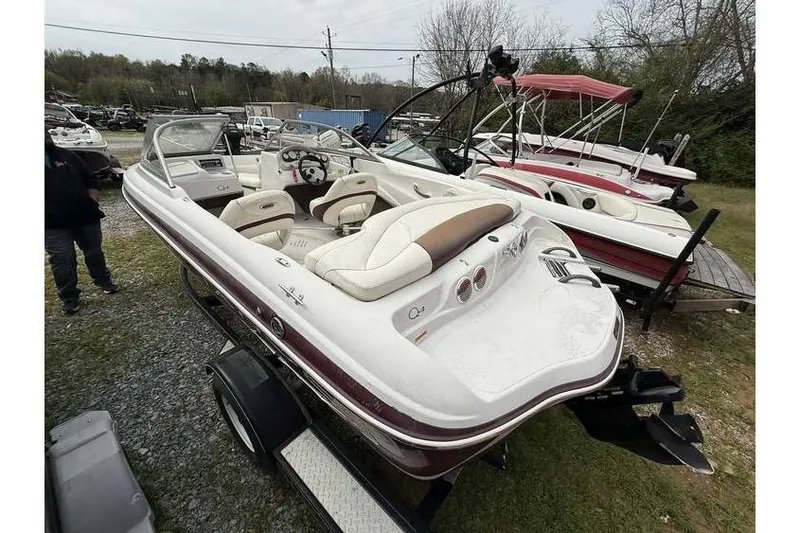 Slide: The Image of 2009 Tahoe Q4 SF boat on trailer, parked outdoors, with other boats nearby. - 7