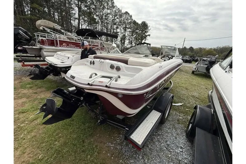 Slide: The Image of 2009 Tahoe Q4 SF boat on trailer, parked outdoors with other boats. - 8