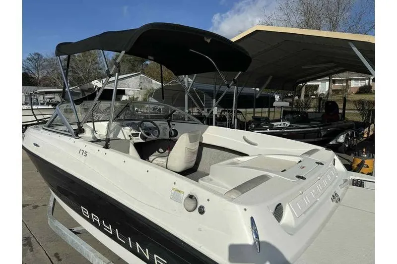 Slide: The Image of 2012 Bayliner 175 Bowrider boat with canopy, parked under a shelter. - 10