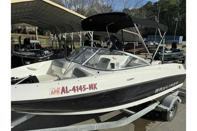 Slide: The Image of 2012 Bayliner 175 Bowrider boat on trailer, parked under a canopy. - 12