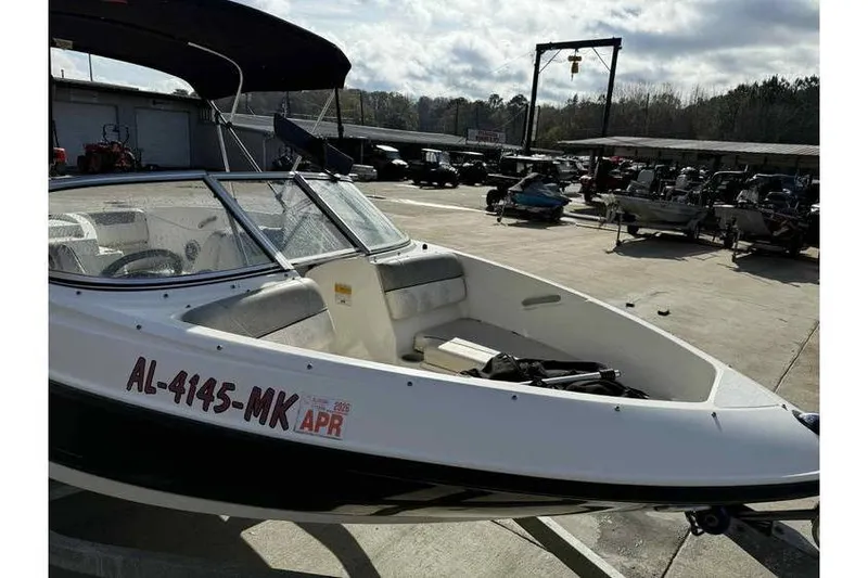 Slide: The Image of 2012 Bayliner 175 Bowrider boat parked in a marina with registration visible. - 4