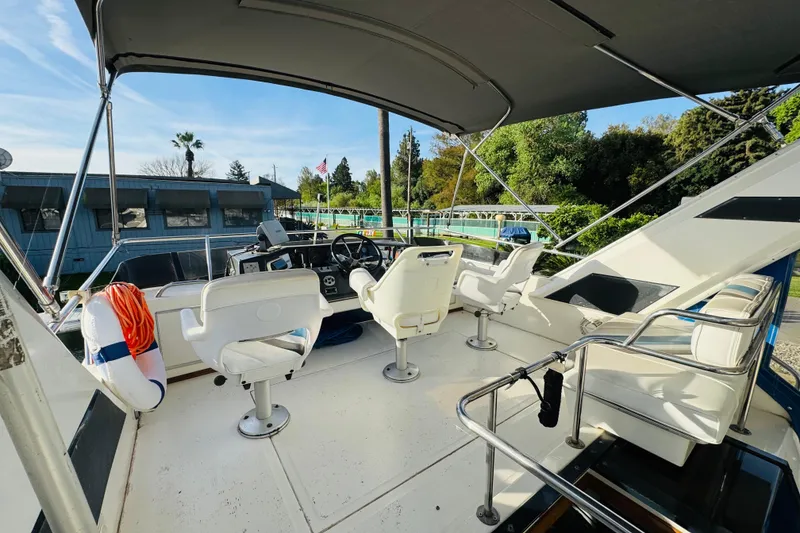 Slide: The Image of 1991 Sea Ray 380 Aft Cabin boat deck with seating and steering wheel. - 11