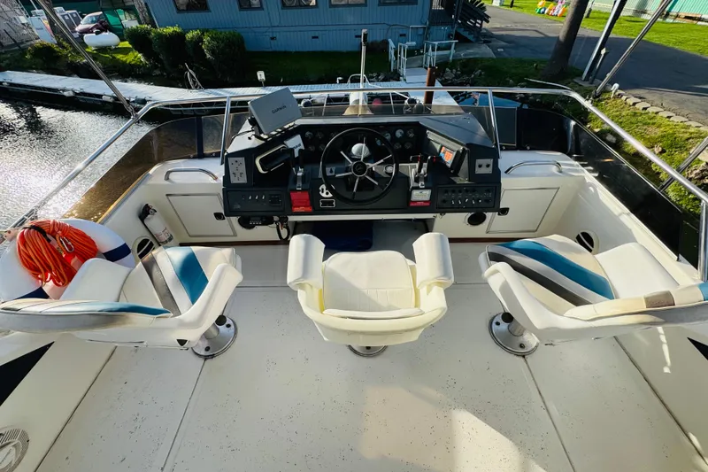 Slide: The Image of Cockpit of 1991 Sea Ray 380 Aft Cabin with steering wheel and seating. - 13