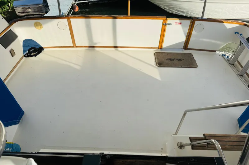 Slide: The Image of 1991 Sea Ray 380 Aft Cabin boat deck with clean white surface and wooden accents. - 20
