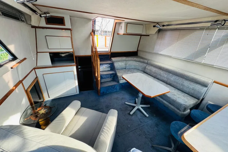 Slide: The Image of 1991 Sea Ray 380 Aft Cabin interior with blue carpet, seating, and dining table. - 24