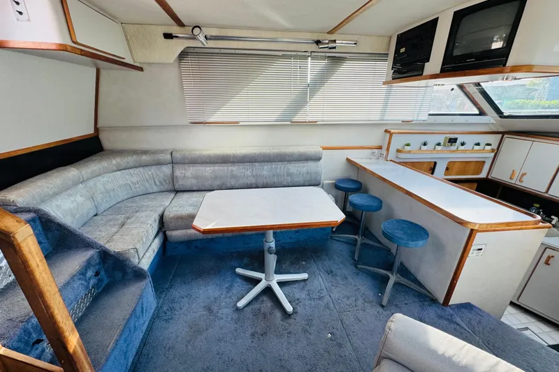 Slide: The Image of 1991 Sea Ray 380 Aft Cabin interior with seating, table, and bar stools. - 26