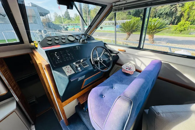 Slide: The Image of 1991 Sea Ray 380 Aft Cabin helm with steering wheel and control panel. - 28
