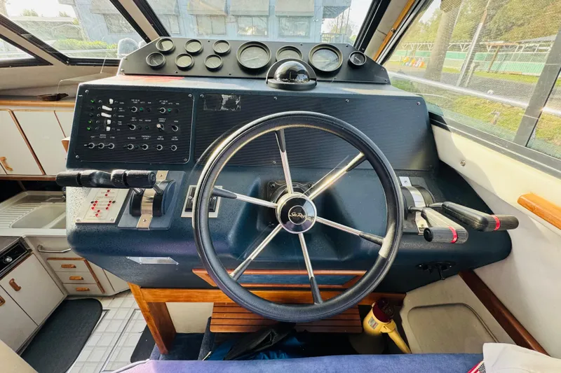 Slide: The Image of 1991 Sea Ray 380 Aft Cabin helm with steering wheel and control panel. - 29