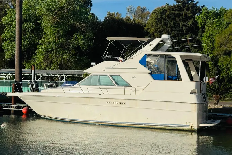 Slide: The Image of 1991 Sea Ray 380 Aft Cabin yacht docked by lush greenery. - 3