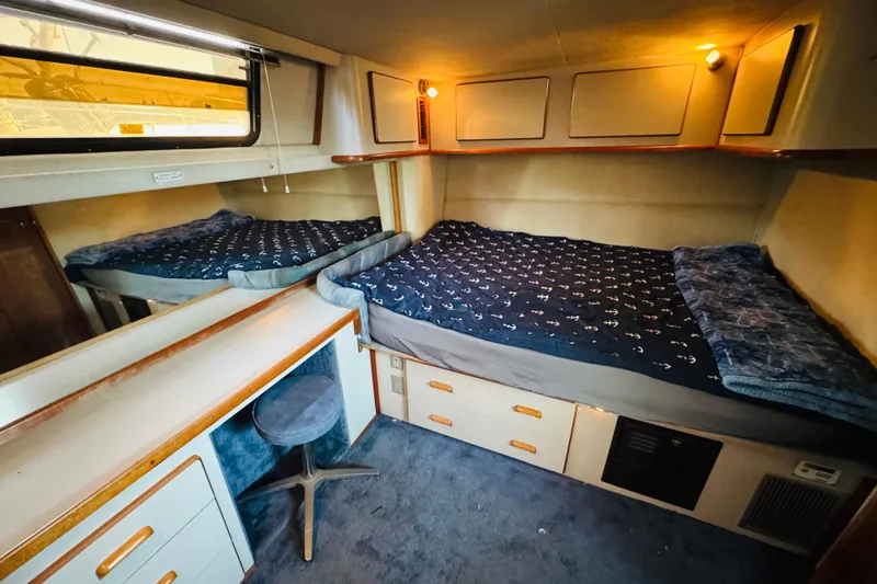 Slide: The Image of Cozy cabin interior of 1991 Sea Ray 380 Aft Cabin with twin beds and storage. - 33