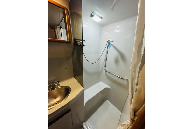 Slide: The Image of 1991 Sea Ray 380 Aft Cabin bathroom with shower, sink, and mirror. - 36