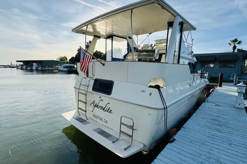 Slide: The Image of 1991 Sea Ray 380 Aft Cabin yacht docked, featuring "Aphrodite" name and American flag. - 6