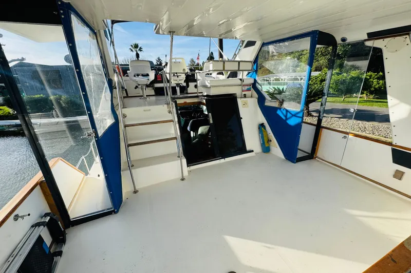 Slide: The Image of 1991 Sea Ray 380 Aft Cabin interior with helm, seating, and open deck view. - 7