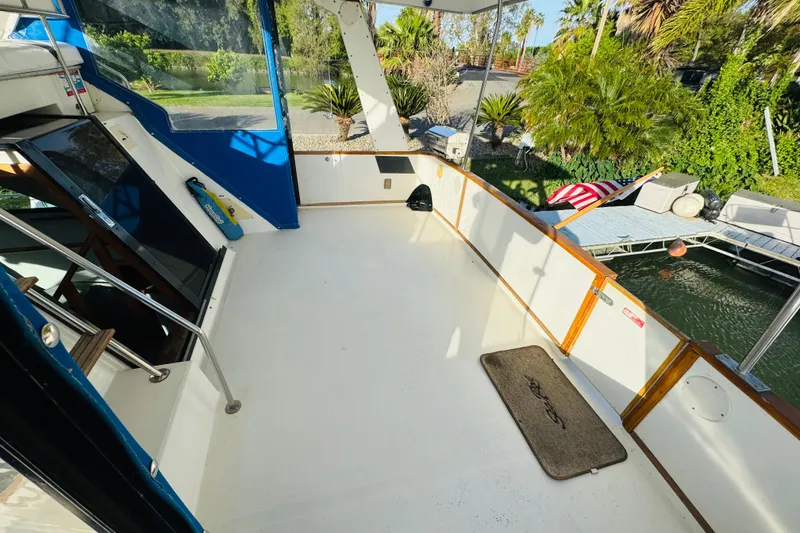 Slide: The Image of Spacious deck of 1991 Sea Ray 380 Aft Cabin yacht, docked near lush greenery. - 8