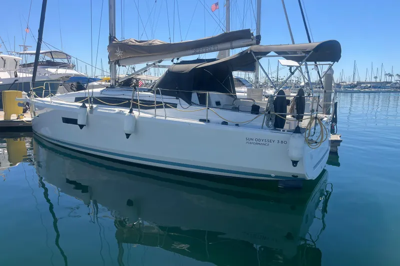 The Image of 2023 Jeanneau Sun Odyssey 380 sailboat docked in a marina under clear blue skies. - 0