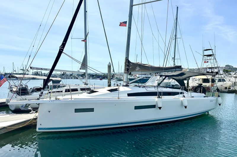 Slide: The Image of 2023 Jeanneau Sun Odyssey 380 sailboat docked in a marina, showcasing sleek design and modern features. - 1