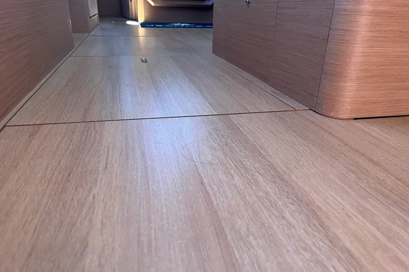 Slide: The Image of Interior view of 2023 Jeanneau Sun Odyssey 380, showcasing sleek wooden flooring. - 11