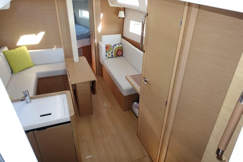 Slide: The Image of 2023 Jeanneau Sun Odyssey 380 interior with modern wood finish and cozy seating area. - 14