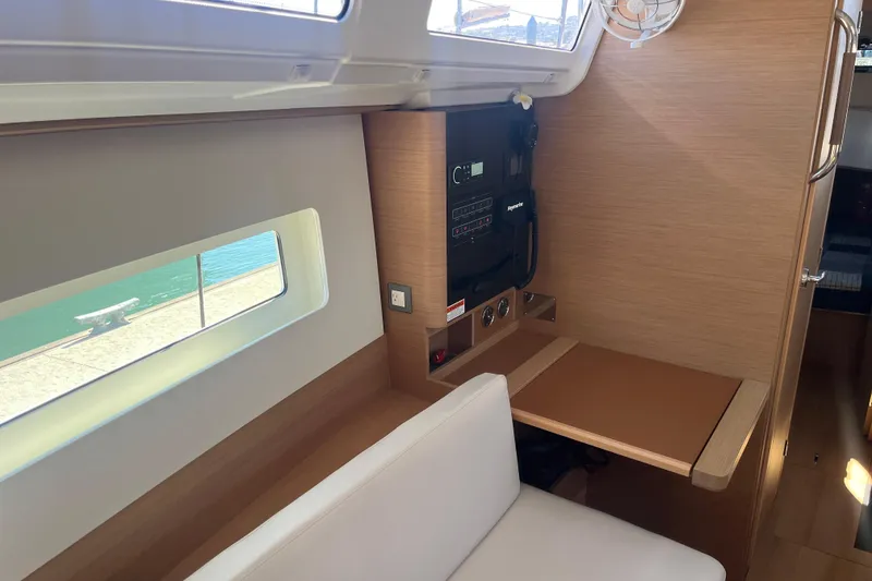 Slide: The Image of Interior of 2023 Jeanneau Sun Odyssey 380 yacht, featuring a navigation station and window view. - 16