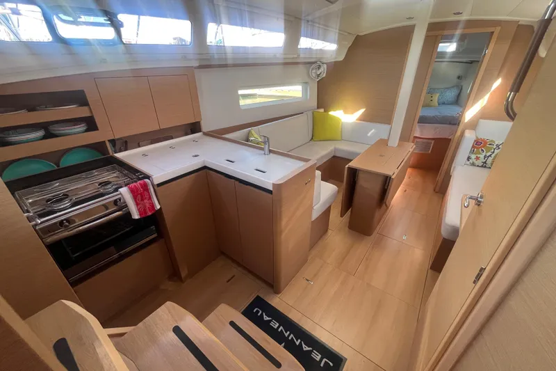 Slide: The Image of Interior of 2023 Jeanneau Sun Odyssey 380 yacht, featuring modern kitchen and cozy seating area. - 21