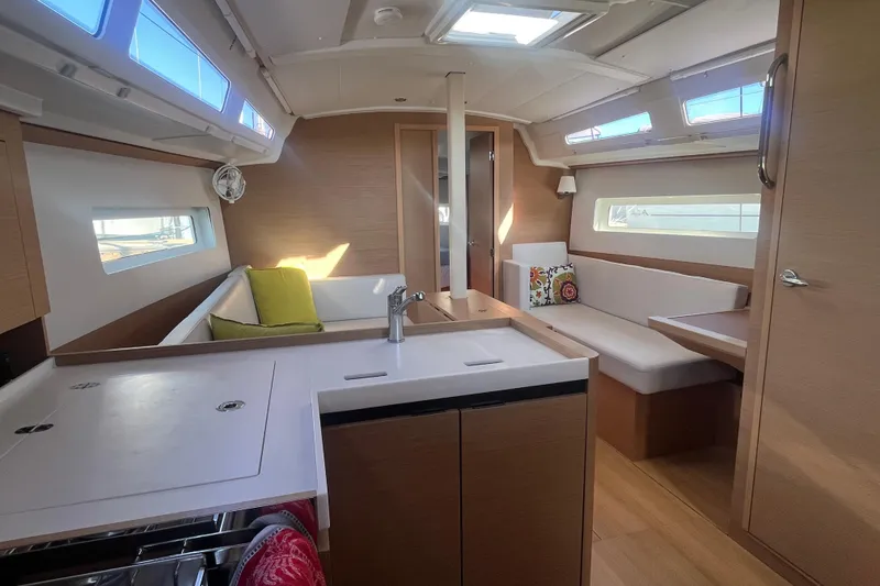 Slide: The Image of Interior of 2023 Jeanneau Sun Odyssey 380 yacht, featuring modern kitchen and cozy seating area. - 22