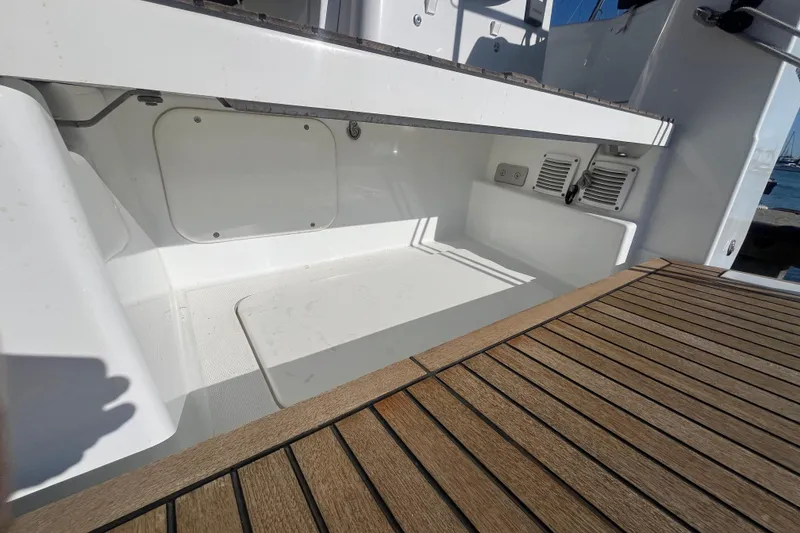 Slide: The Image of 2023 Jeanneau Sun Odyssey 380 yacht deck with wood finish and storage compartment. - 48
