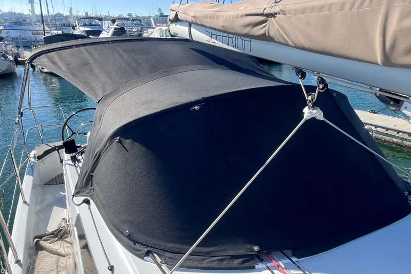Slide: The Image of 2023 Jeanneau Sun Odyssey 380 sailboat with black canopy docked at marina. - 51