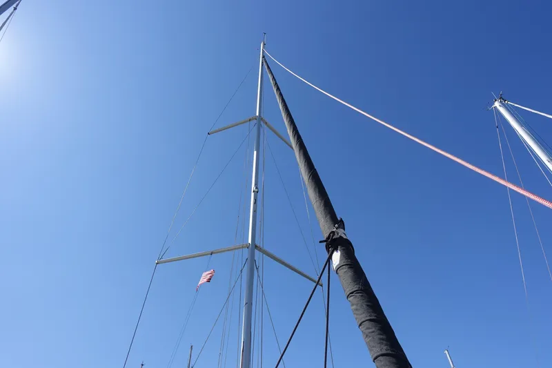 Slide: The Image of Mast of 2023 Jeanneau Sun Odyssey 380 sailboat against clear blue sky. - 59