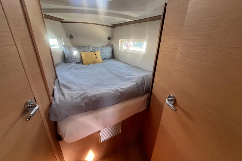 Slide: The Image of Cozy cabin interior of 2023 Jeanneau Sun Odyssey 380 sailboat with bed and pillows. - 6