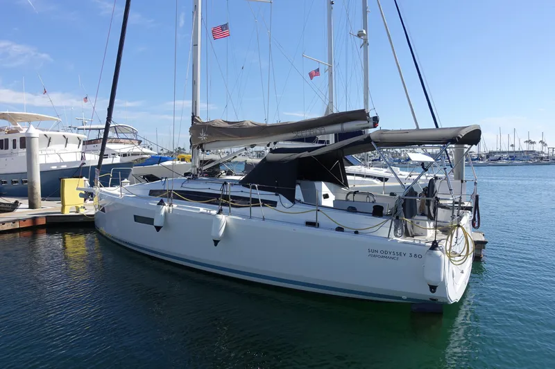 Slide: The Image of 2023 Jeanneau Sun Odyssey 380 sailboat docked in a marina under clear blue skies. - 65