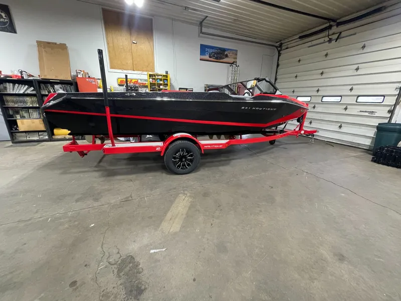 The Image of 2026 Nautique Ski Nautique boat in garage on red trailer. - 1