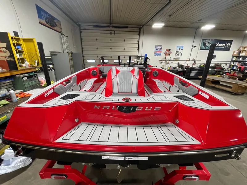 Slide: The Image of 2026 Nautique Ski Nautique boat in red color inside a workshop. - 7